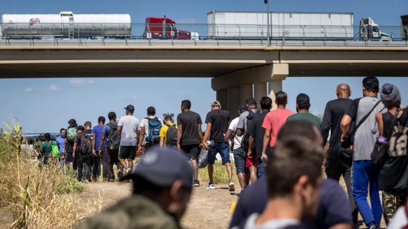 Inmigrantes ilegales caminan hacia un puesto de control de la Patrulla Fronteriza de EE.UU. después de cruzar la frontera entre Estados Unidos y México, en Eagle Pass, Texas, el 28 de septiembre de 2023. (John Moore/Getty Images)
