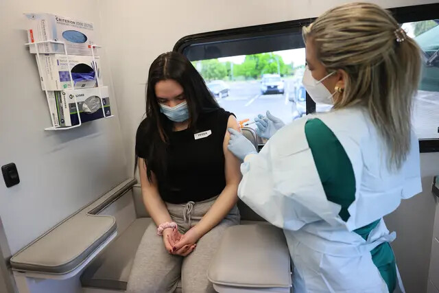 Una mujer recibe una vacuna anti-COVID de Pfizer-BioNTech en la clínica móvil pediátrica de UHealth, en Miami, Florida, el 17 de mayo de 2021. (Joe Raedle/Getty Images)
