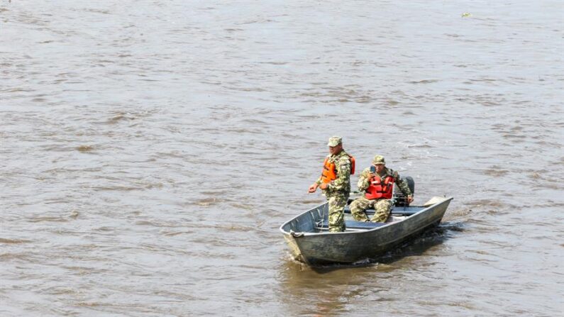 Soldados buscan un vehículo con dos militares a bordo tras las fuertes lluvias el 2 de noviembre de 2023, en Lambaré (Paraguay). EFE/ Christian Alvarenga