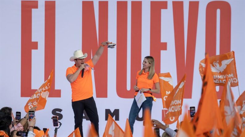 El precandidato a la presidencia de México por el partido Movimiento Ciudadano (MC), Samuel García (i), en compañía de su esposa, Mariana Rodríguez, habla durante un acto de pre-campaña, hoy, en la norteña ciudad de Monterrey, México. (EFE/ Miguel Sierra)