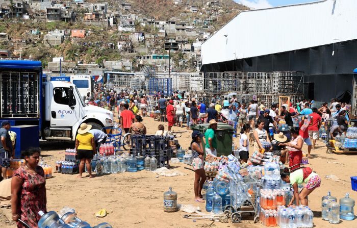 Personas se abastecen de agua por el paso del huracán Otis, en el balneario de Acapulco, en el estado de Guerrero, México, el 26 de octubre de 2023. (EFE/David Guzmán)