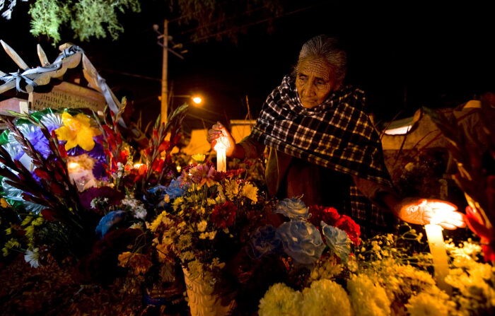 Una señora realiza una vigilia en el cementerio de Mixquic en Tláhuac, Ciudad de México, el 2 de noviembre durante la temporada de el Día de muertos de 2009. (LUIS ACOSTA/AFP via Getty Images)