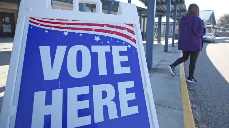 Una persona pasa junto a un cartel durante la segunda vuelta de las elecciones para gobernador de Luisiana, en un colegio electoral de Quitman High School, en Quitman, Luisiana, el 16 de noviembre de 2019. (Matt Sullivan/Getty Images)