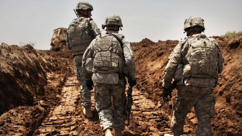 Soldados estadounidenses del 3º Regimiento de Caballería Blindada patrullan una nueva zanja que han cavado para proteger la base de ataques el 19 de julio de 2011 en Iskandariya, provincia iraquí de Babil. (Spencer Platt/Getty Images)