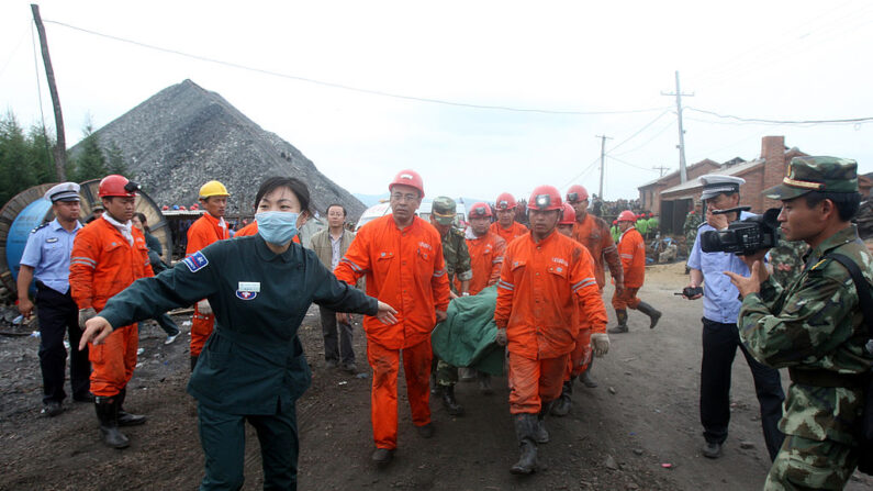 Rescatistas llevan a un minero de carbón en una camilla después de ser rescatado de una mina inundada en Qitaihe, provincia nororiental china de Heilongjiang, el 30 de agosto de 2011. (STR/AFP vía Getty Images)