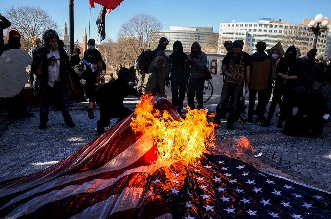 Miembros del Partido Comunista de EE.UU. y otros grupos antifascistas queman una bandera estadounidense en las escaleras del Capitolio del Estado de Colorado el 20 de enero de 2021 en Denver, Colorado. (Michael Ciaglo/Getty Images)