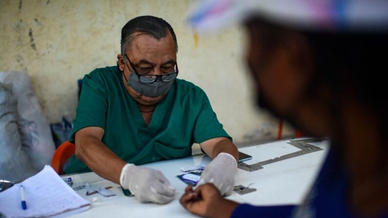 Un médico realiza pruebas de VIH y sífilis a un migrante haitiano en el albergue Terraza Fandango en Ciudad Acuña, estado de Coahuila, México, el 24 de septiembre de 2021.(PEDRO PARDO/AFP vía Getty Images)
