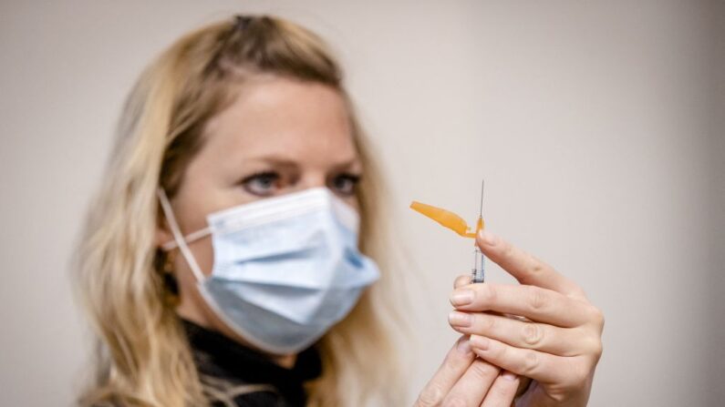 Una trabajadora sanitaria prepara una vacuna contra la gripe durante el inicio de la campaña nacional de vacunación anual contra la gripe en el centro de salud de Parkwijk, en Utrecht, el 17 de octubre de 2022. (SEM VAN DER WAL/ANP/AFP via Getty Images)