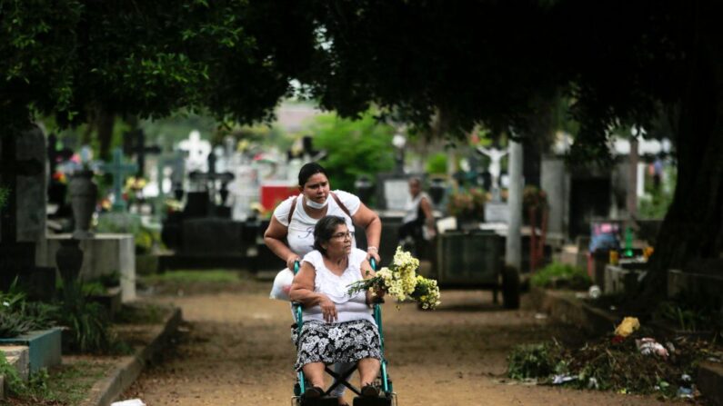 Una mujer en silla de ruedas visita la tumba de sus familiares en el cementerio Central durante la celebración del Día de los Muertos en Managua (Nicaragua), el 2 de noviembre de 2022. (Oswaldo Rivas/AFP vía Getty Images)