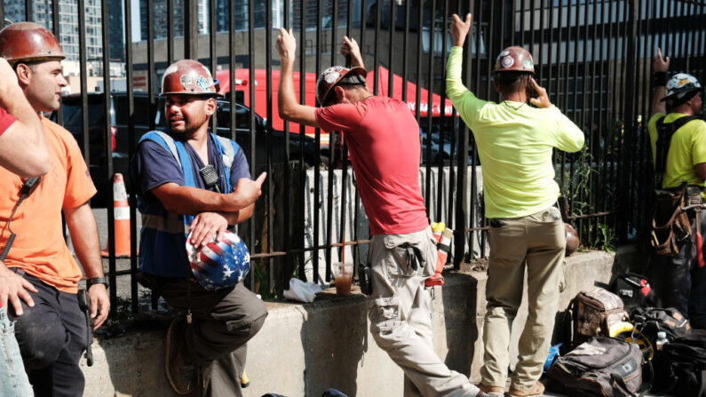 Trabajadores de la construcción descansan en el lugar del colapso de una grúa en el centro de Manhattan el 26 de julio de 2023 en la ciudad de Nueva York. (Spencer Platt/Getty Images)