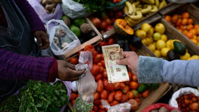 Un hombre paga su compra con billetes de peso argentino en Buenos Aires (Argentina) el 11 de septiembre de 2023. (Luis Robayo/AFP vía Getty Images)