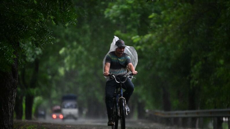 Un hombre monta en bicicleta bajo la lluvia durante la alerta roja decretada por el Gobierno ante la amenaza de que la tormenta tropical Pilar toque tierra, en Jiquilisco, El Salvador, el 31 de octubre de 2023. (Marvin Recinos/AFP vía Getty Images)