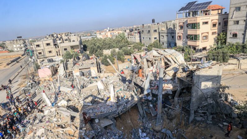 Palestinos buscan supervivientes y víctimas atrapados bajo los escombros de un edificio tras el bombardeo israelí de Rafah, en el sur de la Franja de Gaza, el 10 de noviembre de 2023, en medio de los combates en curso entre Israel y el grupo palestino Hamás. (Said Khatib/AFP vía Getty Images)