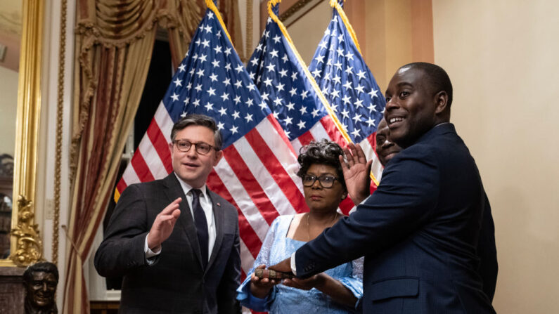 El presidente de la Cámara de Representantes, Mike Johnson (R-La.) (izquierda), participa en la ceremonia de juramento del nuevo representante Gabe Amo (D-R.I.) en el Capitolio en Washington el 13 de noviembre de 2023. (Drew Angerer/Getty Images)