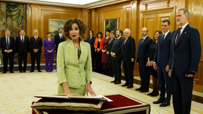 La ministra española de Presupuestos, María Jesús Montero, jura la Constitución ante el rey Felipe VI (d) durante la ceremonia de investidura de los nuevos ministros, en el Palacio de la Zarzuela de Madrid (España), el 21 de noviembre de 2023. (Chema Moya/POOL/AFP vía Getty Images)
