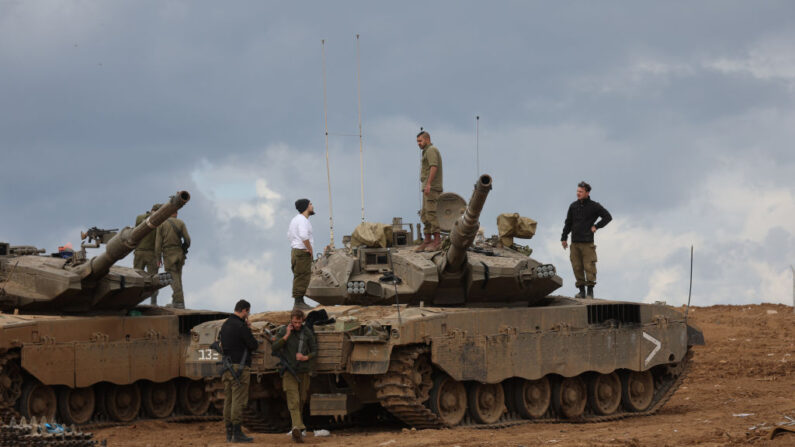 Miembros de las Fuerzas de Defensa Israelíes (IDF) trabajan en una zona de reagrupamiento cerca de la frontera de Gaza mientras se celebra un alto el fuego de seis días entre Israel y miembros de Hamás para la liberación de prisioneros y rehenes el 28 de noviembre de 2023 en Sderot, Israel. (Spencer Platt/Getty Images)