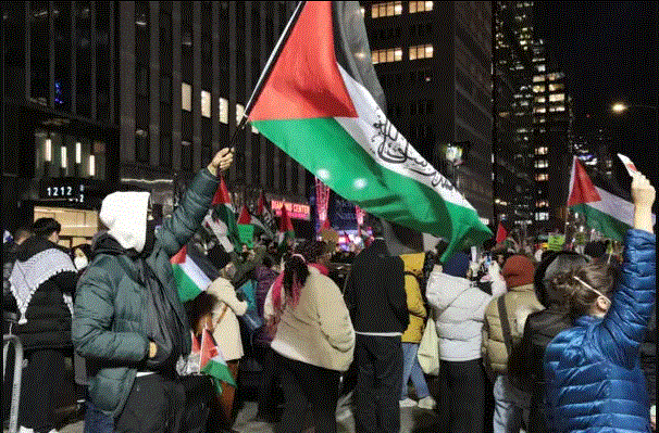 Manifestantes ondean una bandera palestina en la 6ª Avenida de Nueva York el 29 de noviembre de 2023. (Richard Moore/The Epoch Times)