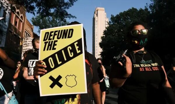 Una manifestante lleva un cartel que dice "Desfinanciar a la policía" durante la marcha "Diga su nombre" de Black Women Matter en Richmond, Virginia, el 3 de julio de 2020. (Eze Amos/Getty Images)