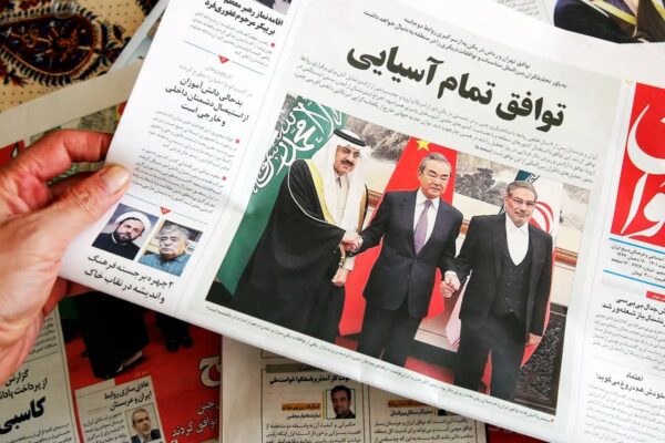 Un hombre en Teherán sostiene un periódico local que informa sobre el acuerdo alcanzado con mediación china entre Irán y Arabia Saudí para restablecer los lazos, firmado en Beijing el día anterior, el 11 de marzo del 2023. (ATTA KENARE/AFP vía Getty Images)