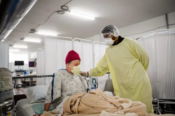 El Dr. Bijay Sah atiende a un paciente en el centro de cuidados alternativos Covid-19, construido en un parqueadero, en el Renown Regional Medical Center, en Reno, Nevada, el 16 de diciembre del 2020. (PATRICK T. FALLON/AFP vía Getty Images)