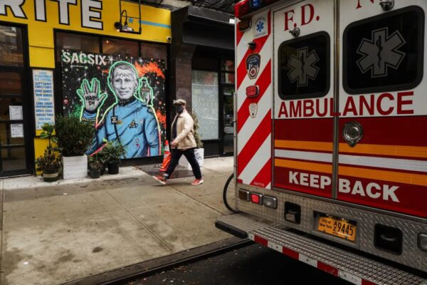 Personas pasan junto a un mural del Dr. Anthony Fauci en Nueva York el 20 de octubre del 2020. El Dr. Fauci criticó recientemente por el presidente Donald Trump sobre la respuesta al COVID-19. (Spencer Platt/Getty Images)