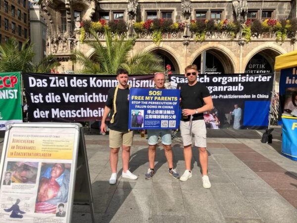 Unos transeúntes sostienen una pancarta de apoyo a Lebin Ding tras enterarse de la persecución de su familia en China, en Múnich, Alemania, el 30 de septiembre del 2023. (Cortesía de Lebin Ding)