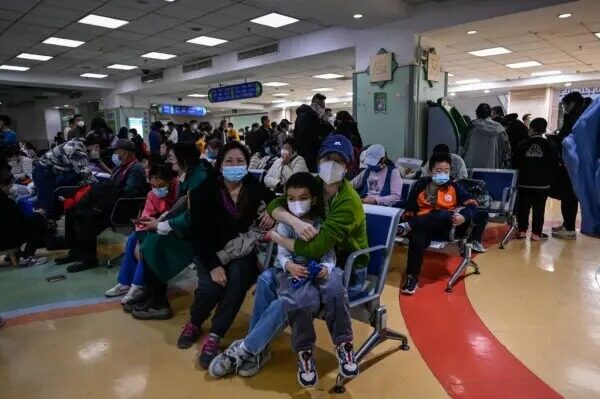 Niños y sus padres esperan en una zona de consultas externas de un hospital infantil de Pekín el 23 de noviembre de 2023. (Jade Gao/AFP vía Getty Images)