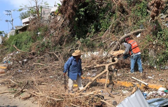 Personas hacen labores de limpieza en una zona afectada tras el paso del huracán Otis, hoy en el municipio de Chilpancingo en el balneario de Acapulco, en el estado de Guerrero, México. (EFE/David Guzmán)