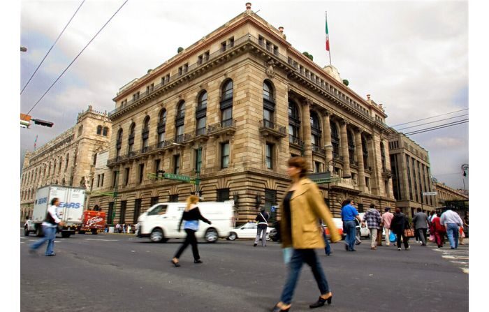 Una foto de archivo de un grupo de personas pasando frente al Banco Central de México en Ciudad de México el 10 de octubre de 2008. (Alfredo Estrella /AFP via Getty Images)