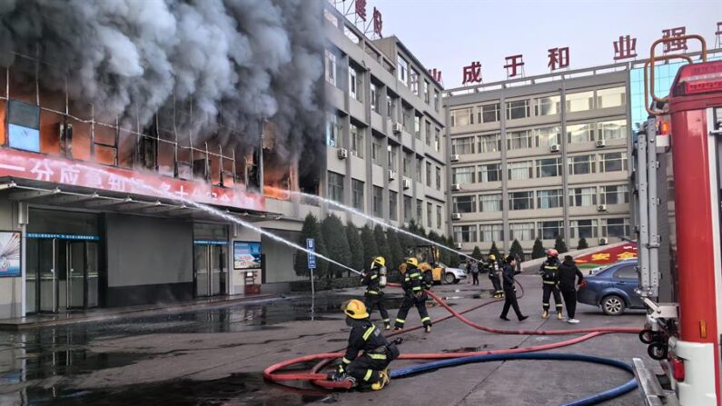 Bomberos trabajan en las labores de extinción de un incendio declarado en un edificio perteneciente a una compañía minera de carbón de la ciudad de Lüliang, en la provincia china de Shanxi (norte), este jueves. Al menos 26 personas han muerto y otras 38 han resultado heridas en el incendio. EFE/Xinhua/Zhan Yan