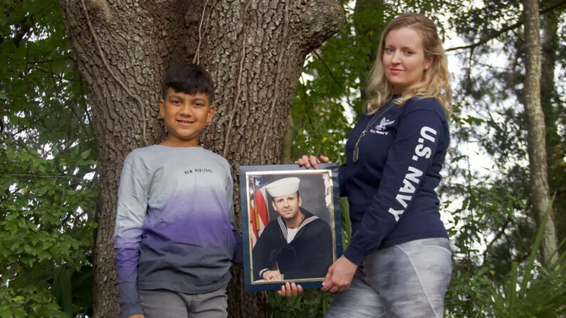 Sabrina Davis (derecha) junto a su hijo Luke Sukhram (izquierda), de 8 años, sostiene una foto de su padre, Keith Davis, en Gainesville, Florida, el 1 de noviembre de 2021, después de que el Sr. Davis falleciera en 2020 por negligencia médica. (Cortesía de Kiara Cline)