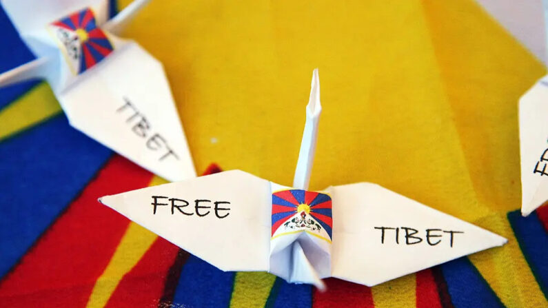 Se ven pájaros de origami "Tíbet libre" mientras manifestantes pro-Tíbet ondean banderas antes de que el Dalai Lama ofrezca una rueda de prensa en el Hotel Hilton Narita en Narita, Japón, el 10 de abril de 2008. (Koichi Kamoshida/Getty Images)