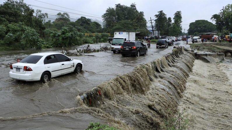 Residentes hondureños transitan por una creciente de agua de una quebrada el 2 de noviembre de 2023 en la ciudad de San Pedro Sula (Honduras). EFE/José Valle