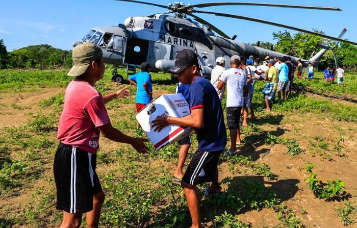 Habitantes de una zona afectada tras el paso del huracán Otis reciben ayuda con despensas, en el poblado de Cacahuatepec, municipio de Acapulco, estado de Guerrero (David Guzmán / EFE)