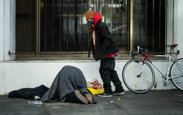 Un hombre observa a una persona consumir drogas en San Francisco, California, el 22 de febrero de 2023. (John Fredricks/The Epoch Times)
