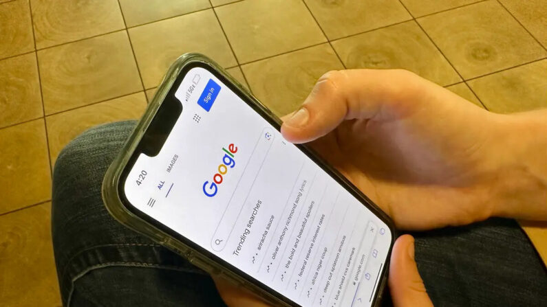 Una mujer sostiene un teléfono inteligente y se prepara para hacer una búsqueda en Google, donde se muestran los términos de búsqueda de tendencia, en Sarasota, Florida, el 18 de agosto de 2023. (Nanette Holt/The Epoch Times)