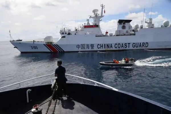 Un barco de la guardia costera china (de color blanco al fondo) bloqueando un barco de la Oficina de Pesca y Recursos Acuáticos de Filipinas (BFAR) mientras su personal a bordo de un bote inflable de casco rígido navegaba junto al barco filipino cuando se acercaba al Scarborough Shoal, controlado por China, en el Disputado Mar de China Meridional, el 22 de septiembre de 2023. (Ted Aljibe/AFP vía Getty Images)
