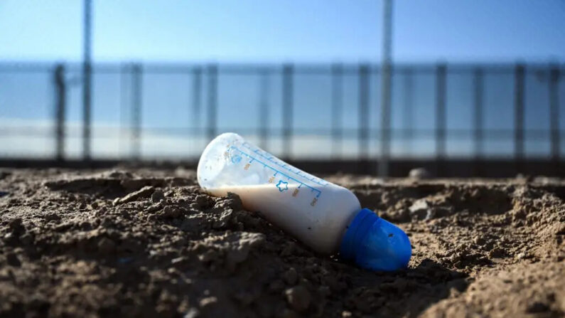Una botella de fórmula de leche para bebés descansa junto a un canal a lo largo del muro fronterizo entre Estados Unidos y México en El Paso, Texas, el 19 de diciembre de 2022. (Foto de PATRICK T. FALLON/AFP vía Getty Images)