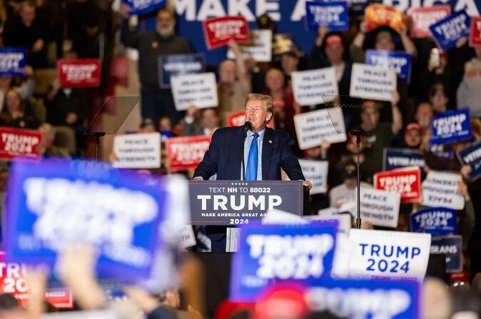 Simpatizantes del expresidente republicano Donald Trump sostienen carteles mientras éste pronuncia un discurso durante un acto de campaña en Claremont, Nuevo Hampshire, el 11 de noviembre de 2023. (Scott Eisen/Getty Images)
