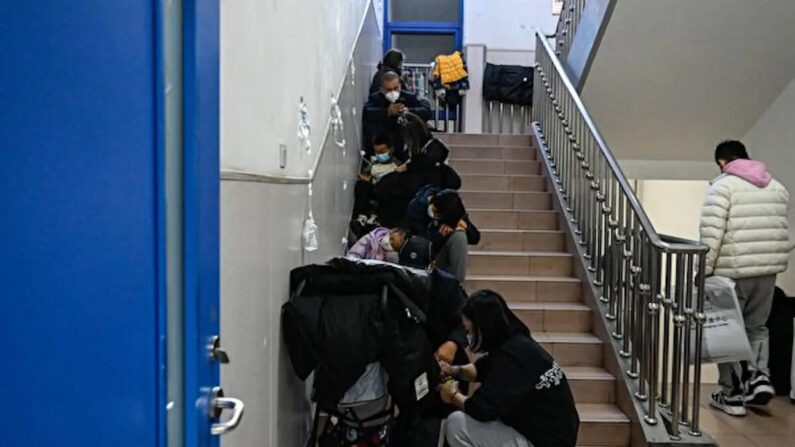 Los niños reciben un goteo en las escaleras de un hospital infantil en Beijing el 23 de noviembre de 2023. La Organización Mundial de la Salud solicitó el 23 de noviembre de 2023 a China más datos sobre una enfermedad respiratoria que se propaga en el norte del país, instando a la gente a tomar medidas para reducir el riesgo de infección. China ha informado de un aumento de "enfermedades similares a la gripe" desde mediados de octubre en comparación con el mismo período de los tres años anteriores, dijo la OMS. (JADE GAO/AFP vía Getty Images)
