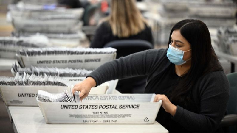 Los trabajadores electorales preparan boletas de votación por correo en el centro de operaciones de votación por correo del Registro del Condado de Los Ángeles en la ciudad de Industry, California, el 4 de noviembre de 2022, para las elecciones de mitad de período del 8 de noviembre. (ROBYN BECK/AFP vía Getty Images)