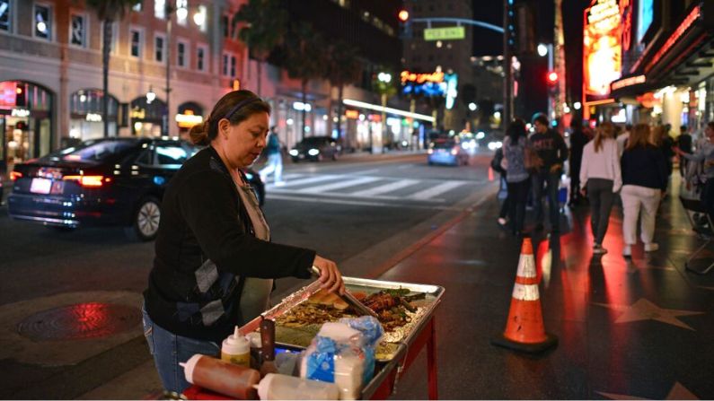 María Navas prepara hot dogs frente al Teatro Dolby en el Paseo de la Fama de Hollywood, en Los Ángeles, el 18 de marzo de 2019. (Agustin PAULLIER/AFP vía Getty Images)