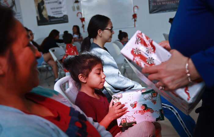 Migrantes que pasan la Navidad en el albergue 'El buen samaritano' reciben regalos, el 24 de diciembre de 2023, en Ciudad Juárez Chihuahua. (EFE/ Luis Torres)