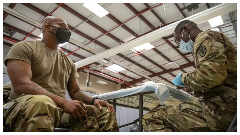 El sargento de primera clase Demetrius Roberson, suboficial de los Servicios de Medicina Preventiva, se prepara para administrar una vacuna COVID-19 a un soldado en Fort Knox, Kentucky, el 9 de septiembre del 2021. (Jon Cherry/Getty Images)