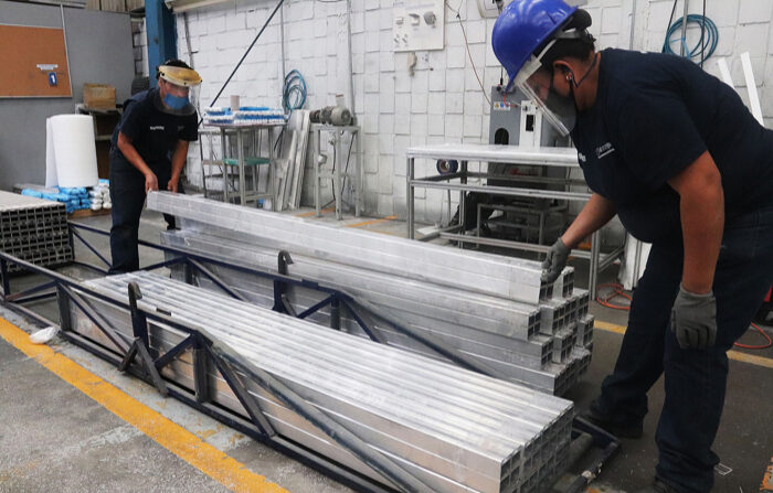 Fotografía de archivo fechada el 3 de junio de 2020 de trabajadores en una fabrica de aluminio de la Ciudad de México. (EFE/José Pazos)