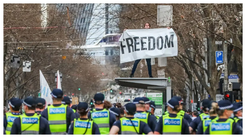 Un hombre sostiene una pancarta en la que se lee "Libertad" en lo alto de una parada de tranvía durante una protesta contra el bloqueo en Melbourne, Australia, el 21 de agosto de 2021. (Getty Images)