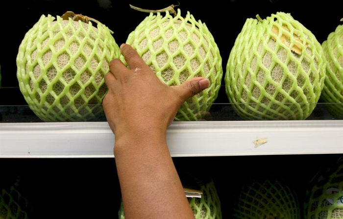 Un cliente intenta alcanzar un melón en una estantería de una verdulería donde se venden frutas y verduras. Imagen de archivo. (EFE/Barbara Walton)
