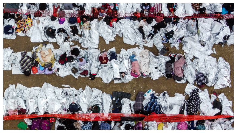 Esta vista aérea muestra a inmigrantes esperando a ser procesados en un centro de tránsito de la Patrulla Fronteriza de Estados Unidos tras cruzar la frontera desde México en Eagle Pass, Texas, el 22 de diciembre del 2023. (Foto de CHANDAN KHANNA/AFP vía Getty Images)