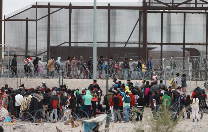 Migrantes hacen fila en el muro fronterizo para intentar cruzar hacia EEUU, el 19 de diciembre de 2023 en ciudad Juárez Chihuahua, México. (EFE/Luis Torres)
