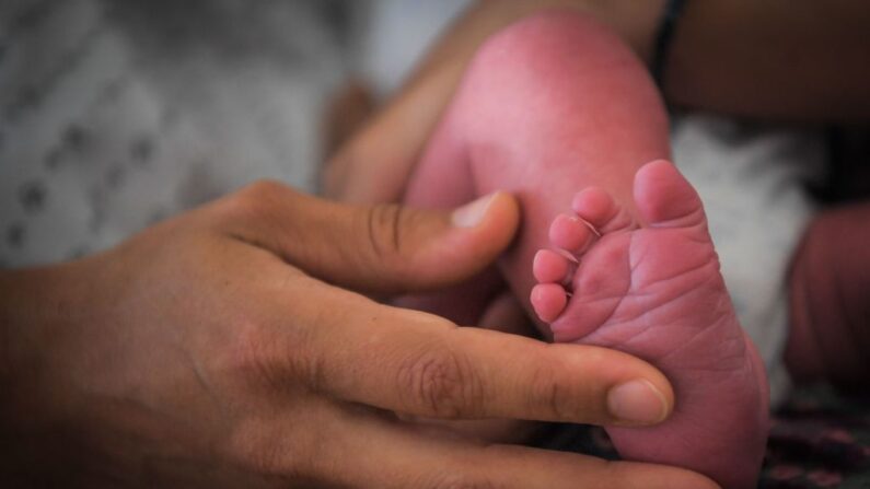 Una mujer sostiene el pie de un bebé en una foto de archivo. (Loic Venance/AFP vía Getty Images)